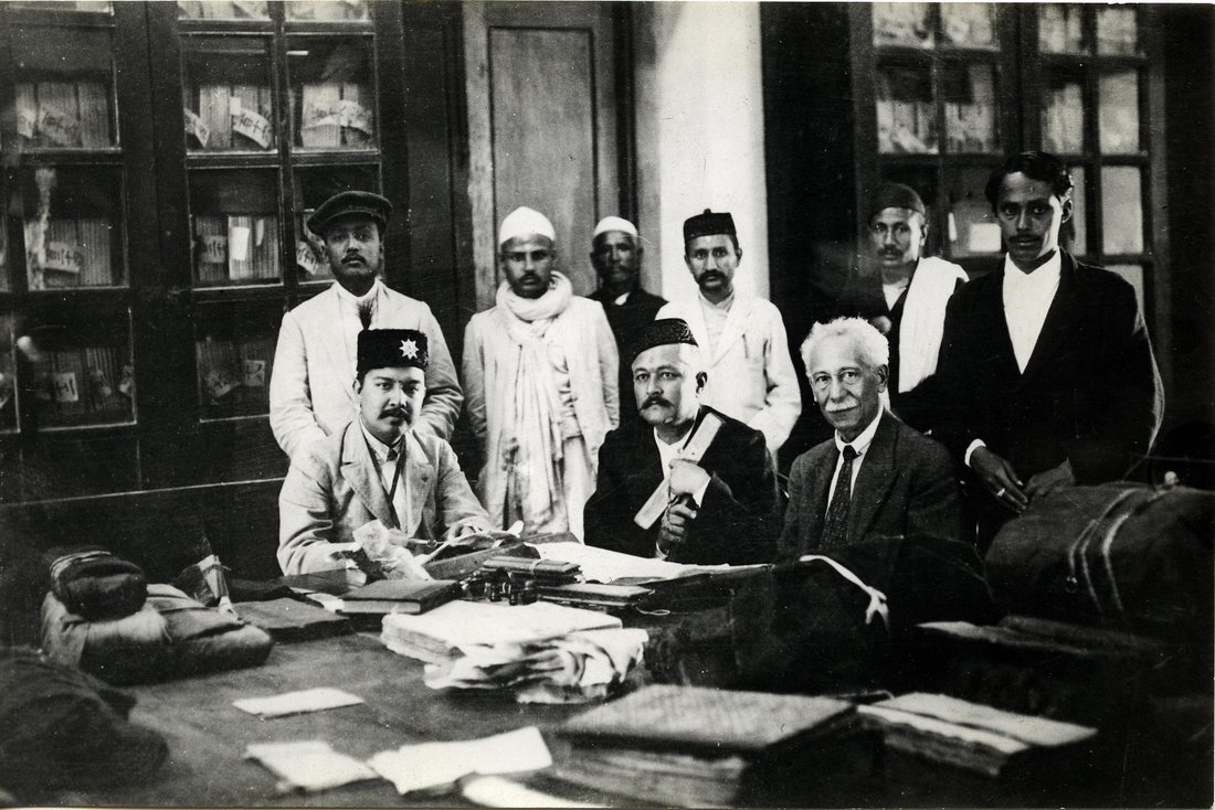 Photographie en noir et blanc d'un groupe d'homme dans une bibliothèque