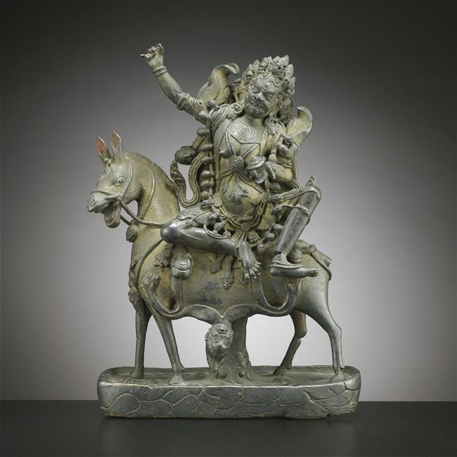 Photographie d'une statuette représentant une déesse assise sur un cheval