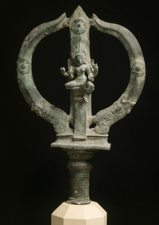 Photograph of a bronze trident with an engraved divinity on the center spike.