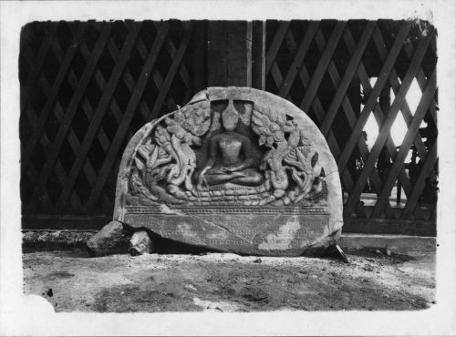 Black and white photograph of a bas-relief representing the Buddha surrounded by flowers