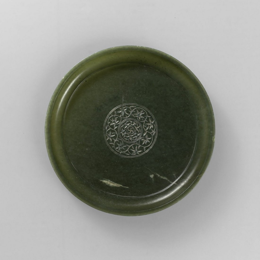 Photograph of a jade cup with a lotus pattern.