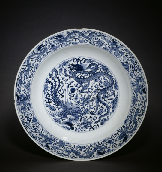 Photograph of a white and blue plate with phoenix and dragons motifs